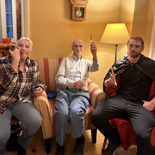 Alec in a vampire cape on Halloween with his grandparents