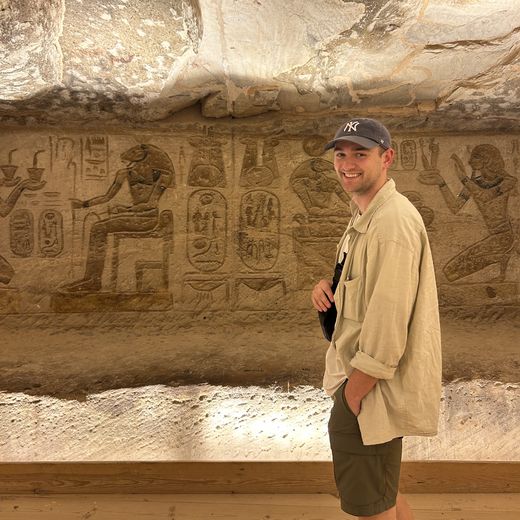 Alec grinning in front of hieroglyphs in a temple