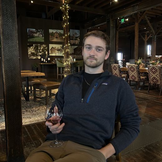 Alec relaxing with a glass of wine at a winery